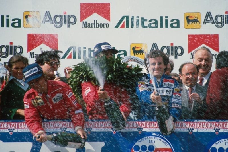 Race winner Patrick Tambay, centre, with second place Alain Prost, right, and third place Rene Arnoux, spray the champagne.