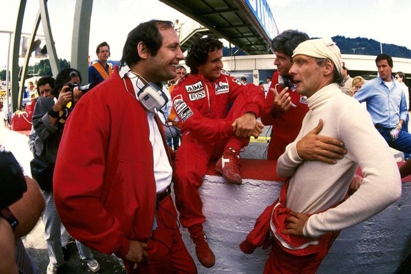 McLaren driver Niki Lauda chats with Team Boss Ron Dennis and race winner Alain Prost.