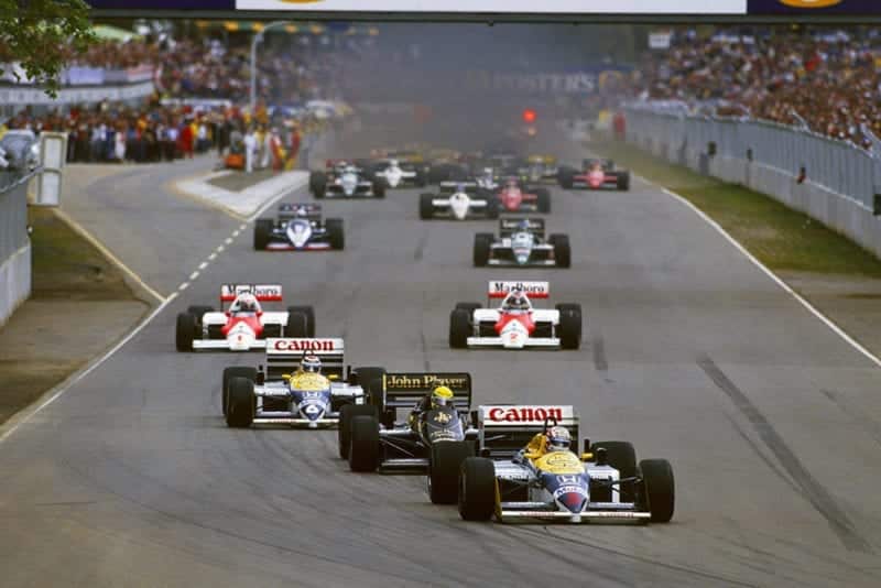 Nigel Mansell in his Williams FW11 Honda leads the field on the warm up lap.