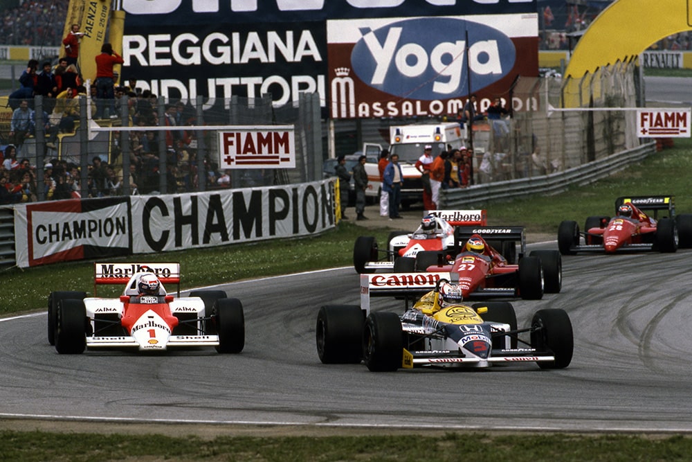 Nigel Mansell, Williams FW11, and Alain Prost, McLaren MP4/2C lead the pack.