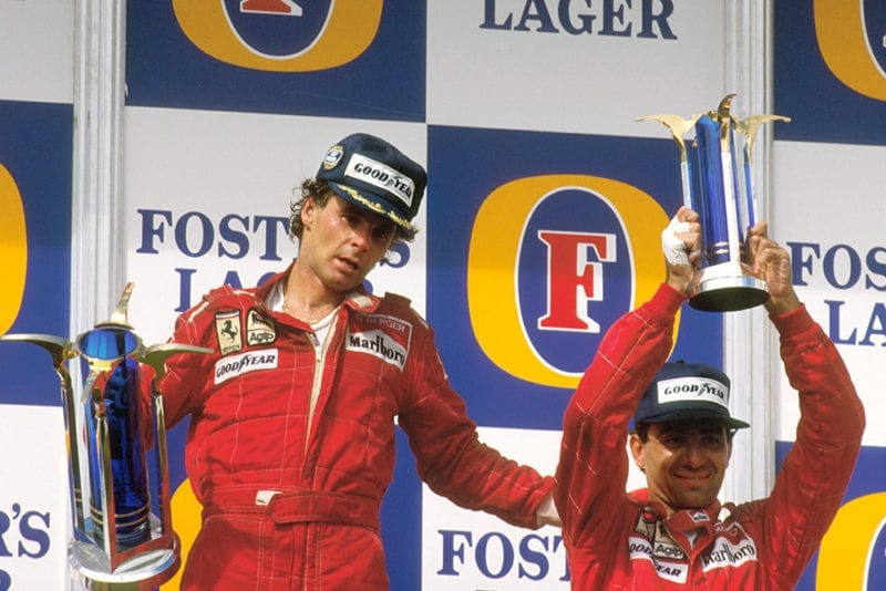 Gerhard Berger, 1st position gives teammate Michele Alboreto, 3rd position (both Ferrari) a pat on the back whilst on the podium.