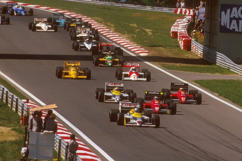 Nigel Mansell (Williams FW11B Honda) leads Gerhard Berger and Michele Alboreto (both Ferrari F187's), Nelson Piquet (Williams FW11B Honda), Alain Prost (McLaren MP4/3 TAG Porsche) and Ayrton Senna (Lotus 99T Honda) at the start.