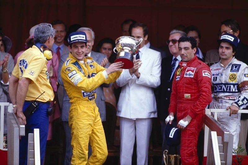 Ayrton Senna, 1st position, Michele Alboreto, 3rd position and Nelson Piquet, 2nd position on the podium. Lotus boss Peter Warr stands next to Senna to collect the constructors prize.
