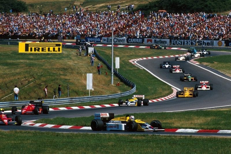 Nigel Mansell, Williams FW11B, leads the field away on lap 1.
