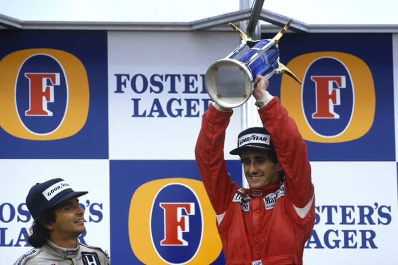 Alain Prost, 1st position, celebrates becoming World Champion again with Nelson Piquet, 2nd position, on the podium.