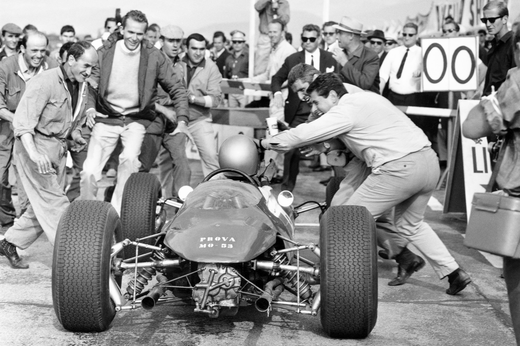 Lorenzo Bandini (Ferrari 156) enters the pits upon winning the race.