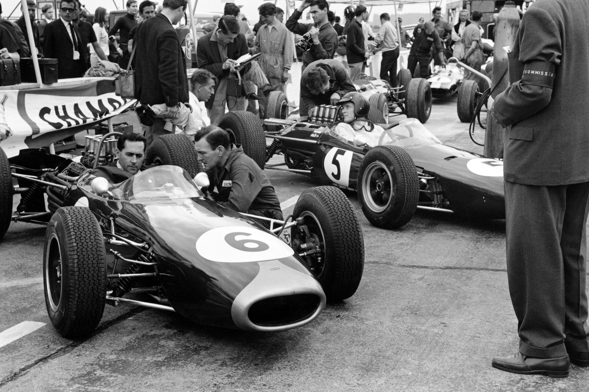 Jack Brabham (Brabham BT11 Climax) and Dan Gurney (Brabham BT7 Climax) wait in the pits