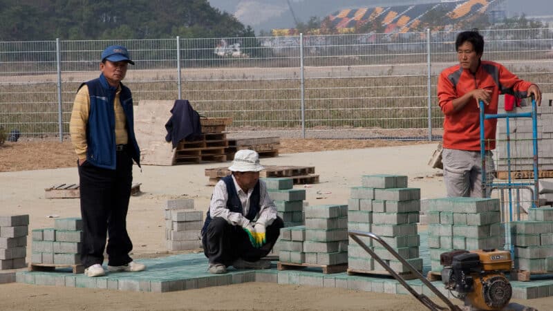Construction workers laying blocks at the Korean Grand Prix circuit in 2010