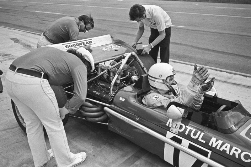 ONTARIO, CA - MARCH 28: Derek Bell waits for mechanics working on his March 701 at the Questor Grand Prix in which Formula One cars competed with Formula A cars on March 28, 1971 in Ontario, California.