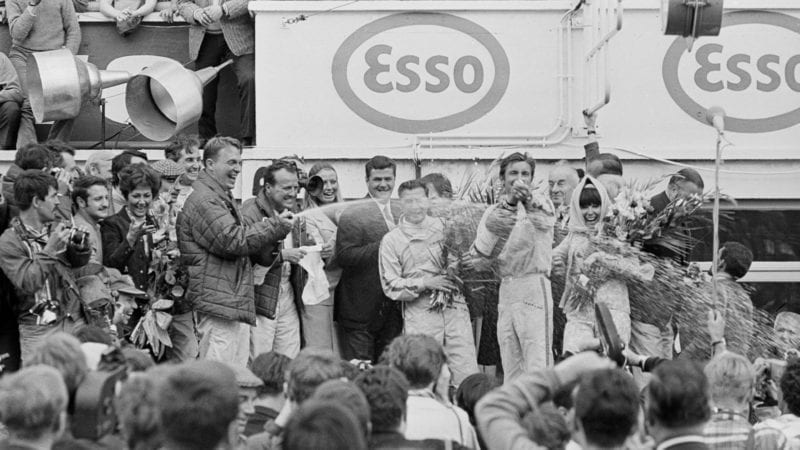 Dan Gurney and AJ Foyt spray champagne on the podium after the 1967 Le Mans 24 Hours