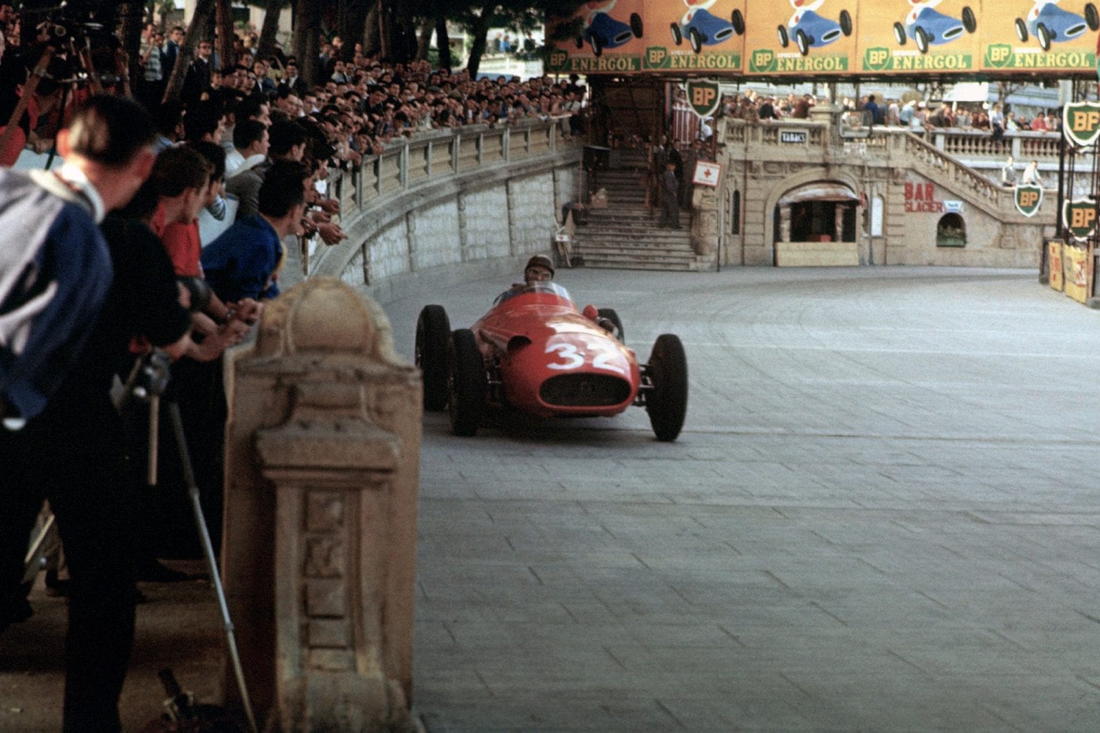Juan Manuel Fangio races past the crowd in his Ferrari at the 1957 Monaco Grand Prix.