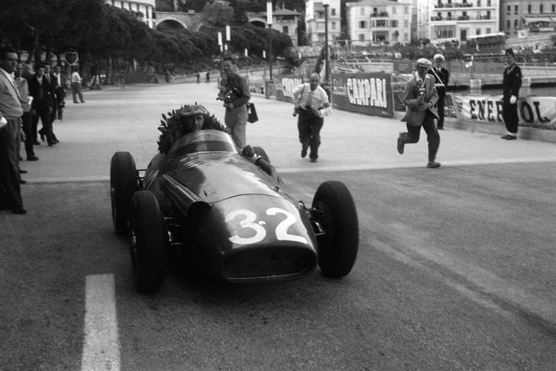 Juan Manuel Fangio has his winner's wreath propped up in the car Maserati 250F, after the race, Monaco