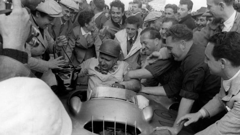 17th July 1954: Racing driver Juan Manuel Fangio (1911- 1995), receiving congratulations after winning the French Grand Prix at Reims in a Mercedes car. Original Publication: Picture Post - 7209 - First Race Of The Mercedes - A Ruthless Triumph - pub. 1954 (Photo by Joseph McKeown/Picture Post/Hulton Archive/Getty Images)
