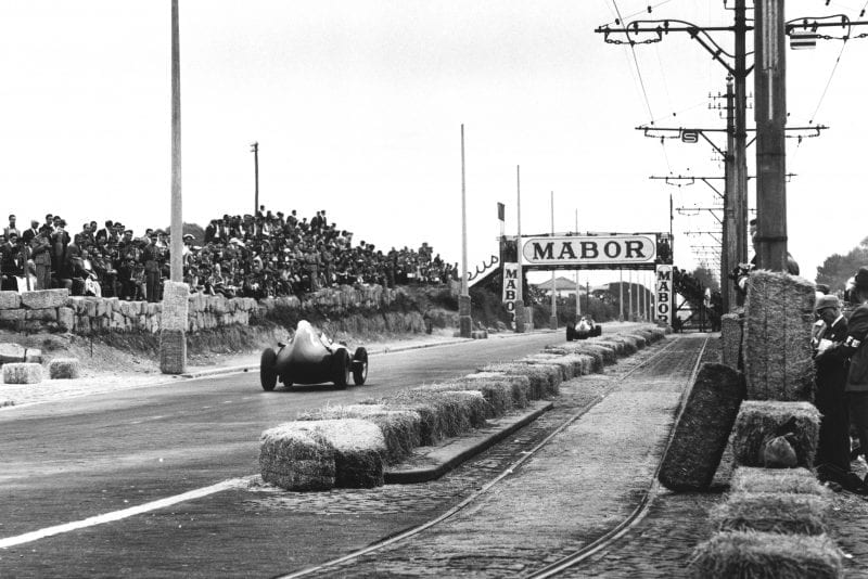 Stirling Moss driving a Vanwall) to 1st place.