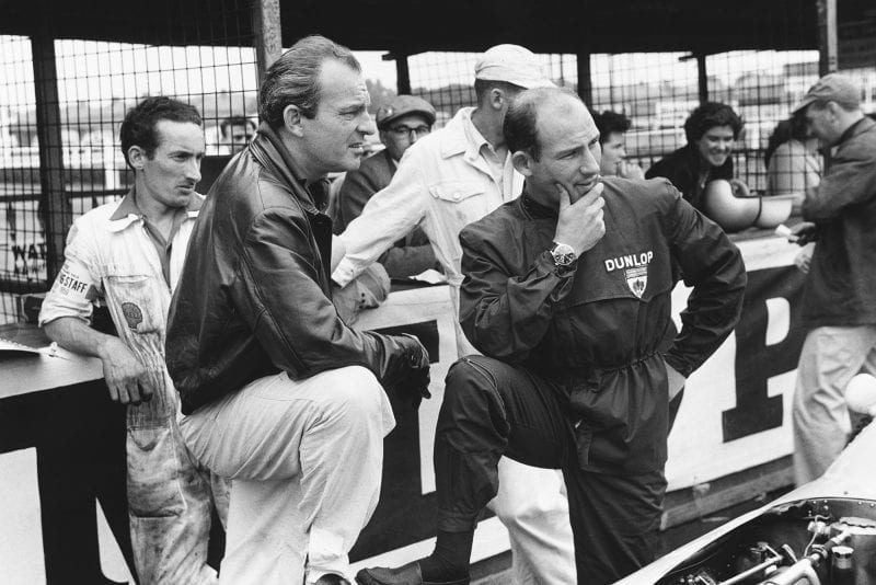 Stirling Moss and Harry Schell chat in the pits.