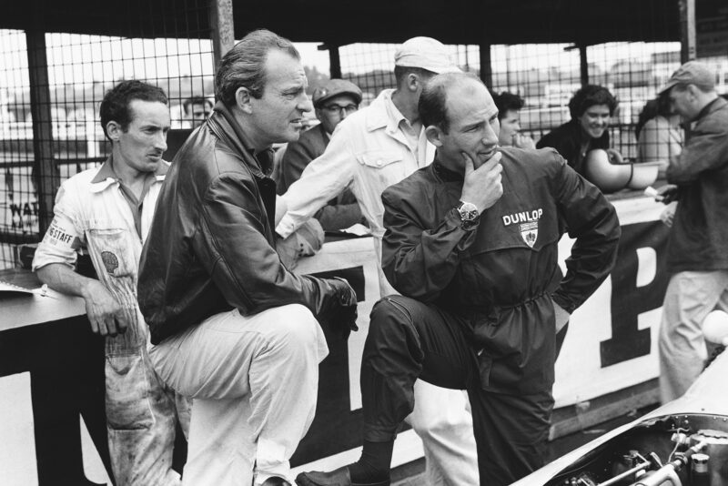 Stirling Moss and Harry Schell chat in the pits.