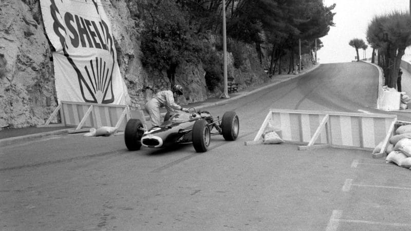Graham Hill pushes his BRM back onto the circuit during the 1965 Monaco Grand Prix. Photo: Grand Prix Photo