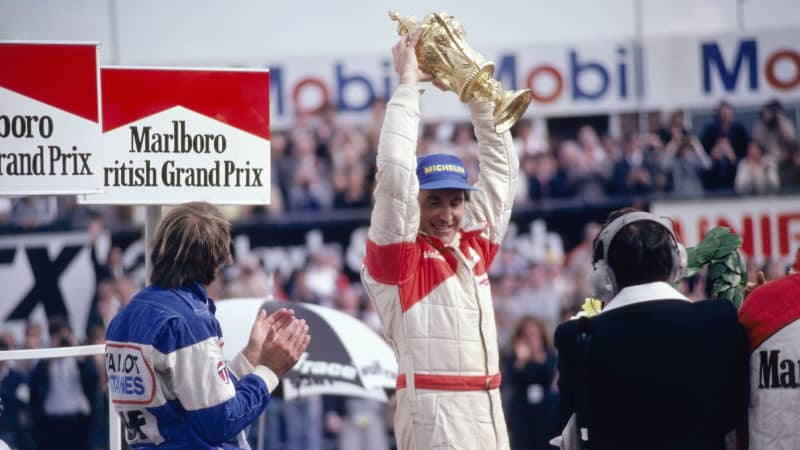 John Watson holds up the British Grand Prix trophy after winning at Silverstone