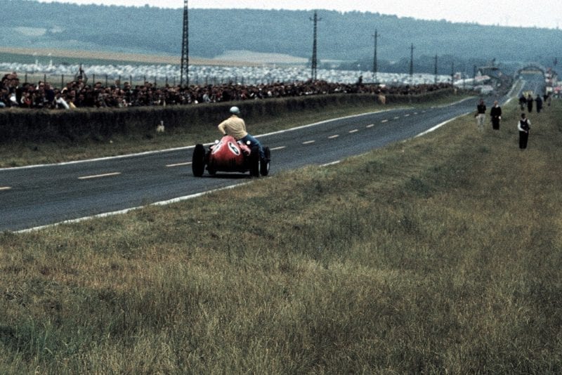 Ferrari's Mairesse gives Vanwall's Brooks a lift back to the pits