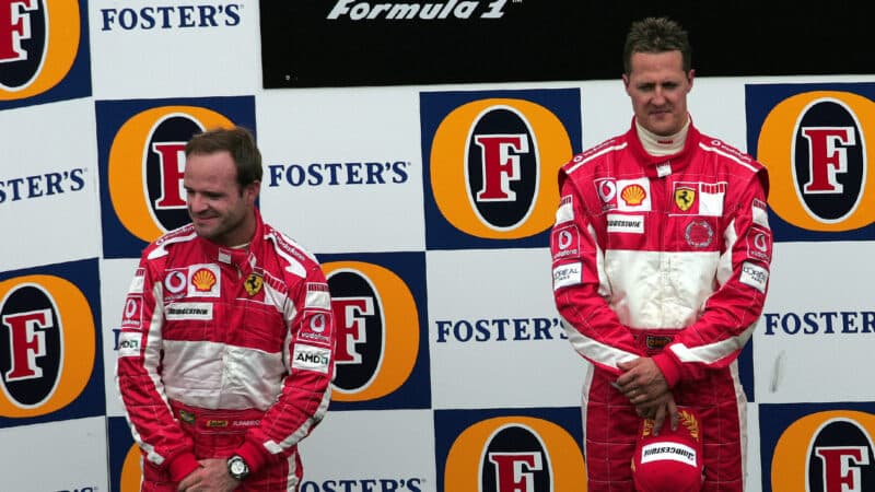 Michael Schumacher and Rubens Barrichello looking in opposite directions on the podium after 2005 F1 United States GP