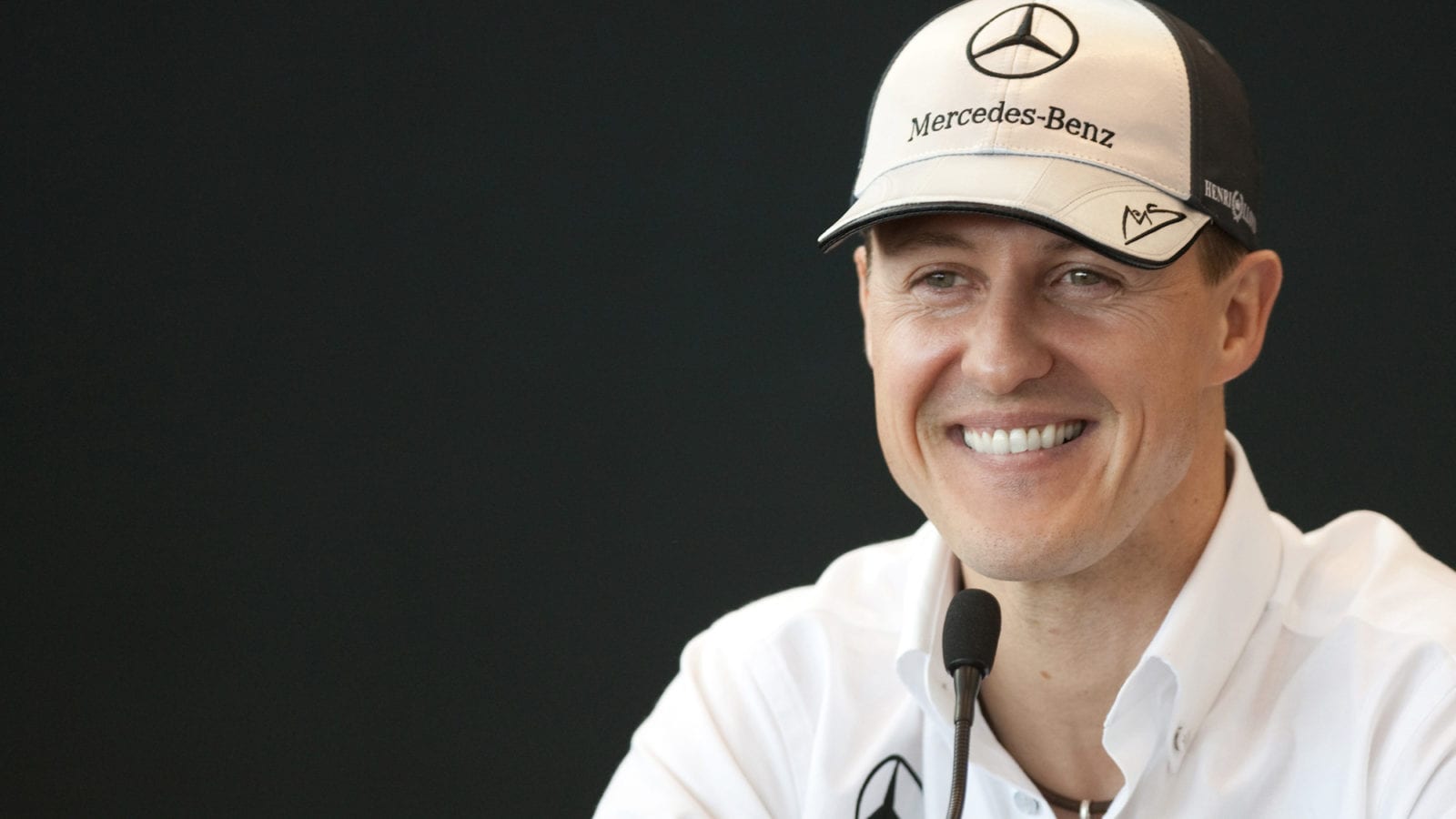 Michael Schumacher smiles in a press conference during his 2010 F1 comeback year