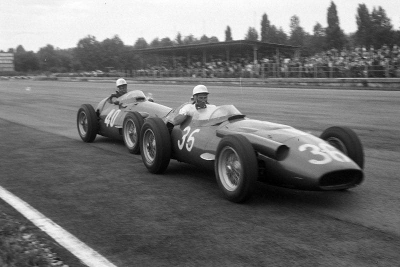 Stirling Moss whose Maserati 250F has run out of fuel, recieves a push back to the pits from team-mate Luigi Piotti, 1956 Italian Grand Prix, Monza.