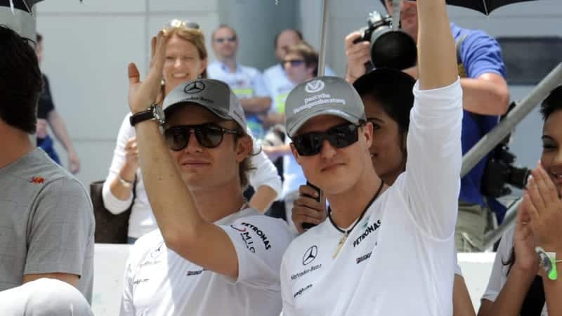 Nico Rosberg waving with Mercedes team-mate Michael Schumacher at the 2010 Malaysian Grand Prix