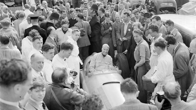 26th August 1950: Crowds surround French BRM racing driver Raymond Sommer after a practice run at Silverstone. (Photo by J. Wilds/Keystone/Getty Images)