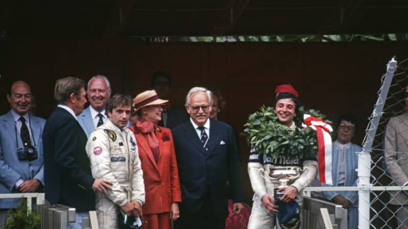 Riccardo Patrese celebrates winning the 1982 Monaco Grand Prix on the podium with trophy
