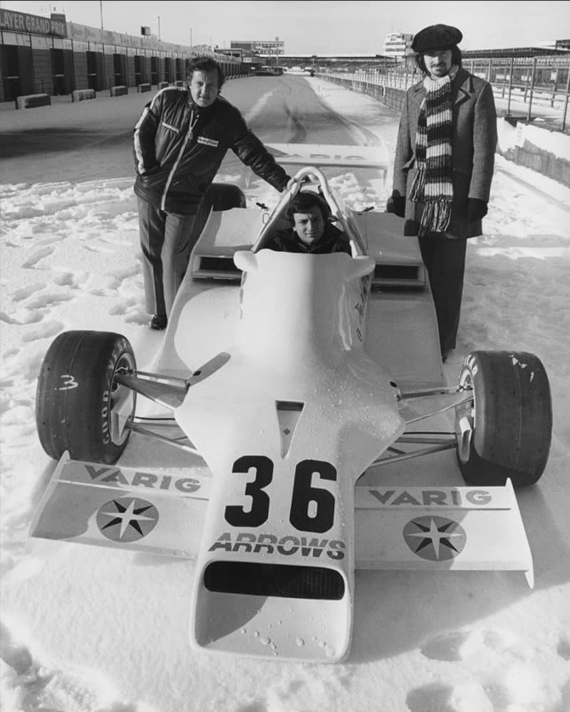 Riccardo Patrese sits in Arrows FA1 between Alan Rees and Tony Southgate in a snow covered Silverstone pitlane
