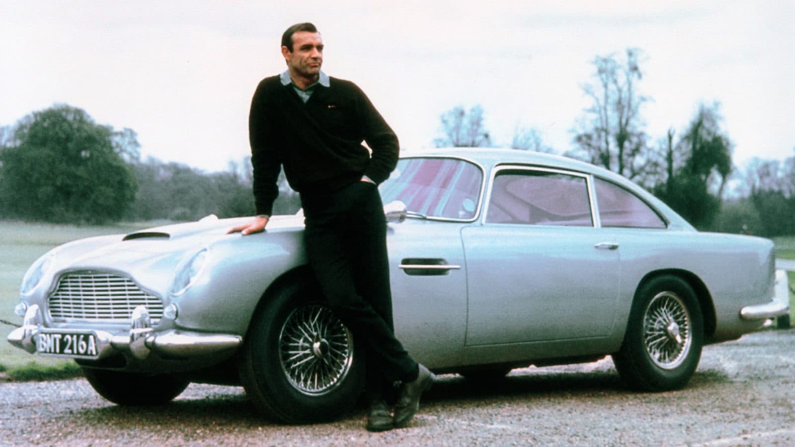 Sean Connery standing with Aston Martin DB5