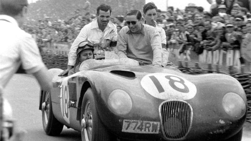 The Le Mans 24 Hours; Le Mans, June 13-14, 1953. Just after the finish Duncan Hamilton drives along the pit straight with a well-cleaned up co-driver Tony Rolt riding next to him. Note the smashed windscreen and Hams broken nose. He had hit a bird at 150 mph on the Mulsanne straight. (Photo by Klemantaski Collection/Getty Images)
