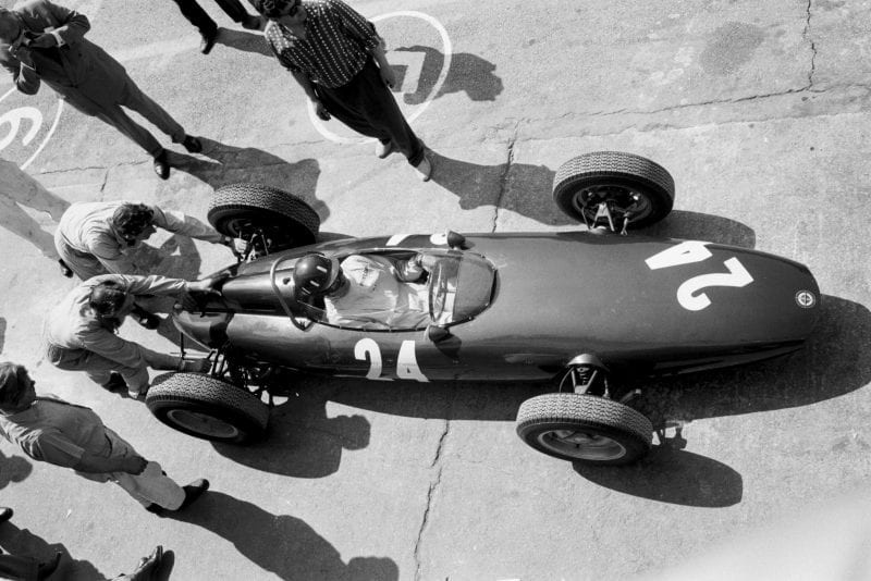 Graham Hill receives a helping hand from his mechanics in the BRM P48/57.