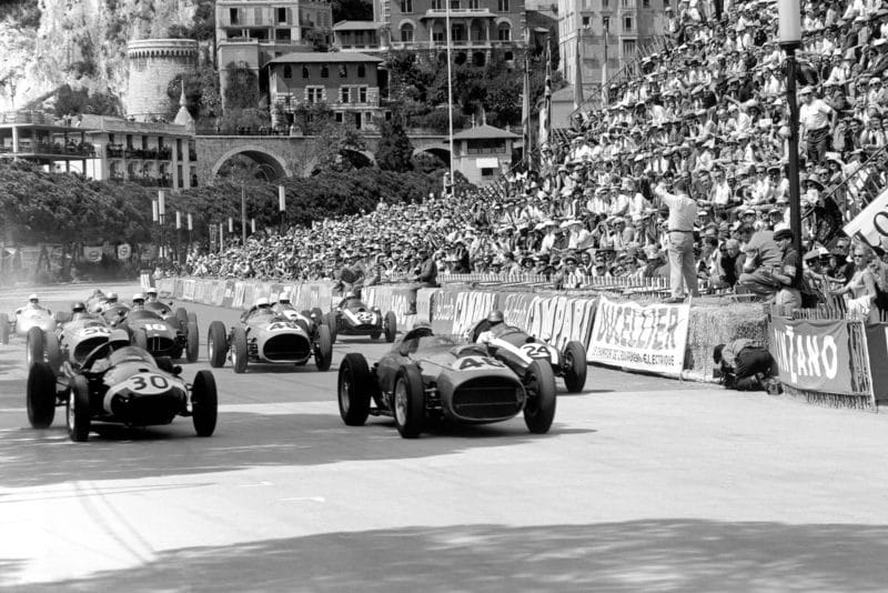 The race starts, with Stirling Moss, number 30 Cooper T51-Climax, and Jean Behra, number 46 Ferrari Dino 246, Tony Brooks in number 50 Ferrari Dino 246, Jo Bonnier, number 18 BRM P25, Phil Hill in number 48 Ferrari Dino 246, and Jack Brabham, number 24 Cooper T51-Climax.