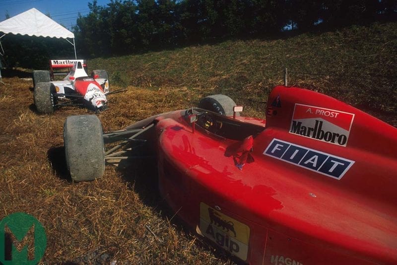 The damaged McLaren and Ferrari cars are parked by the side of the Suzuka track Japanese Grand Prix 1990