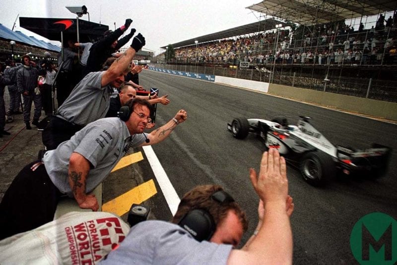 Mika Hakkinen wins the 1998 Brazilian Grand Prix for McLaren-Mercedes, his team celebrating on the pitwall
