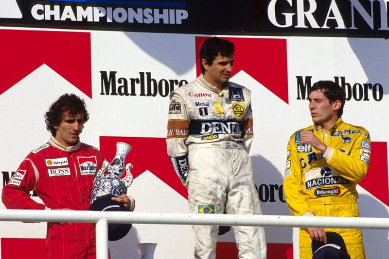 Nelson Piquet (1st) middle, Alain Prost (2nd) McLaren, left and Ayrton Senna (3rd) right on the podium.