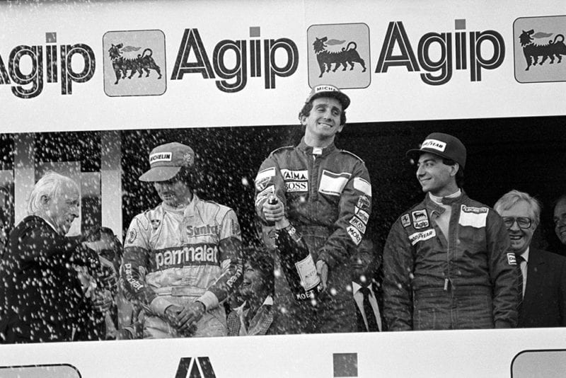 Nelson Piquet (left) third; Alain Prost (centre) first; Michele Alboreto (right) second on the podium.