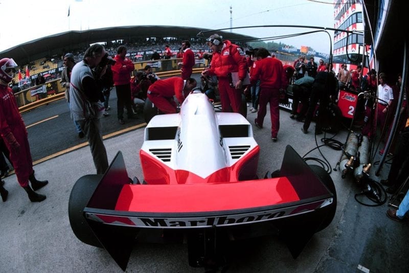 Alain Prost's Mclaren MP4-2C, Jo Ramirez leaning over talking to Prost (left of car).