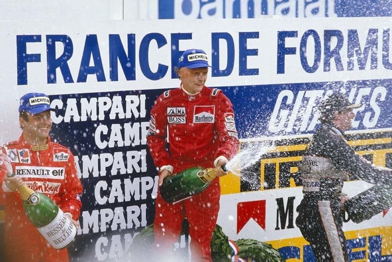 Niki Lauda, 1st position, Patrick Tambay, 2nd position and Nigel Mansell, 3rd position on the podium.
