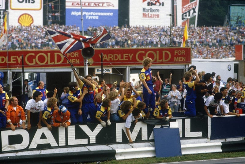 Williams team on the pit wall cheering home Nigel Mansell to 1st place.