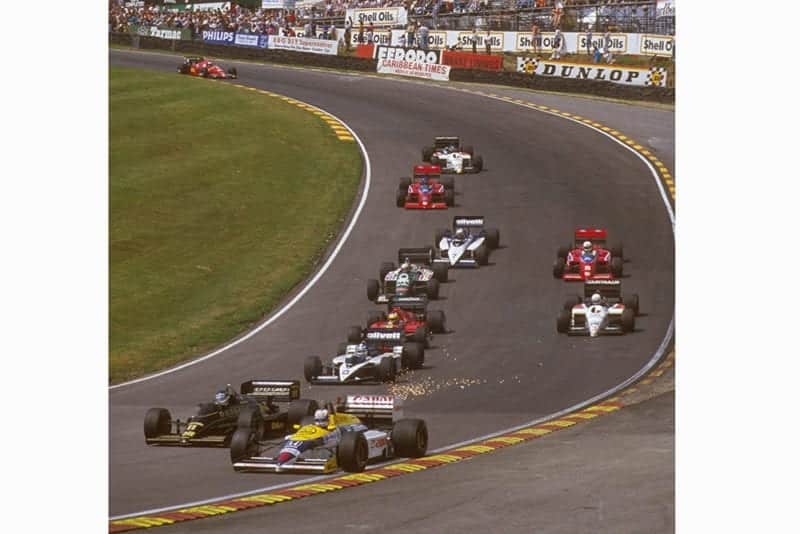 Nigel Mansell in 1st position exits Paddock Hill Bend ahead of the pack.
