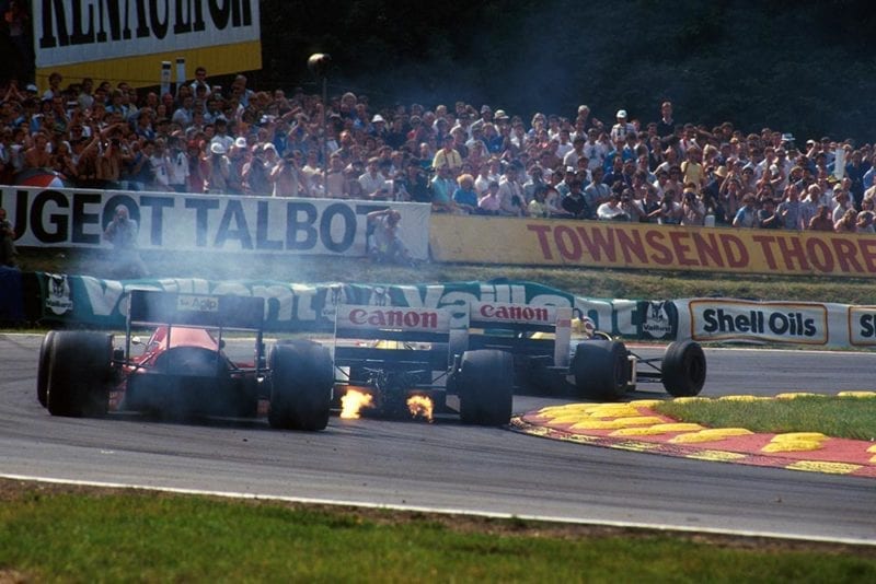 The flame spitting Williams FW11 of Nigel Mansell leads the smoking Ferrari F186.