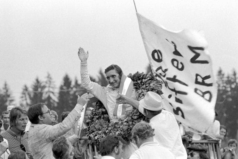 Jo Siffert waves to crowds from the podium after winning the 1971 French Grand Prix.