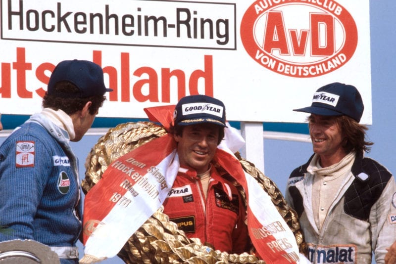 Mario Andretti (Lotus) celebrates on the podium after winning the 1978 German Grand Prix, Hockenheim.