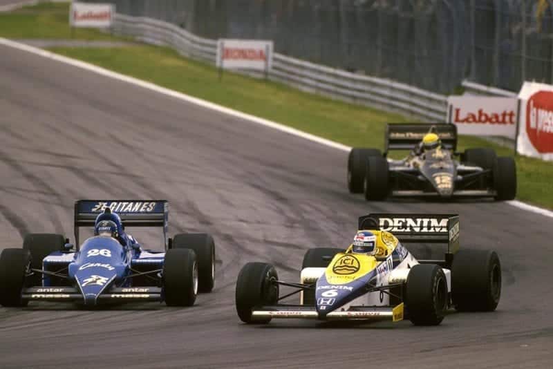 Keke Rosberg in his Williams FW10 passes Jacques Laffite in a Ligier JS25.