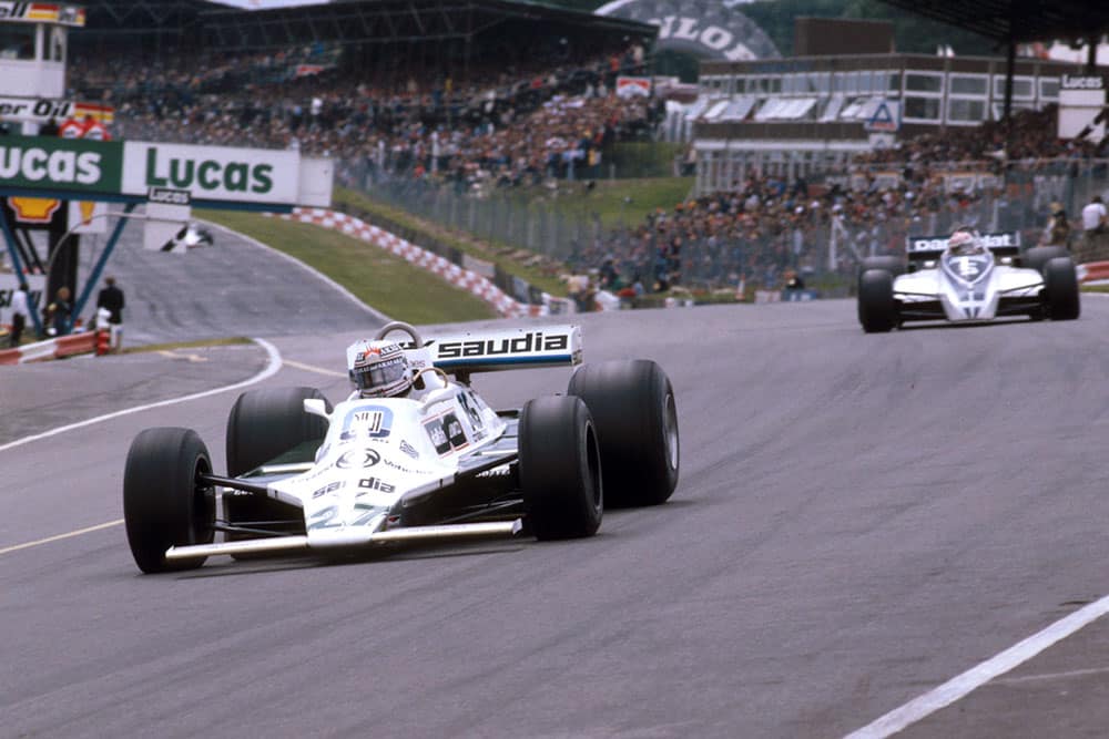Alan Jones (Williams FW07B Ford) at Paddock Hill Bend, with Nelson Piquet (Brabham BT49 Ford) behind.