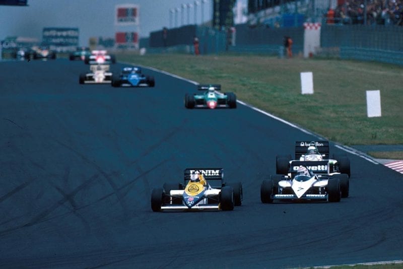 Nigel Mansell in his Williams FW10 leads the field.