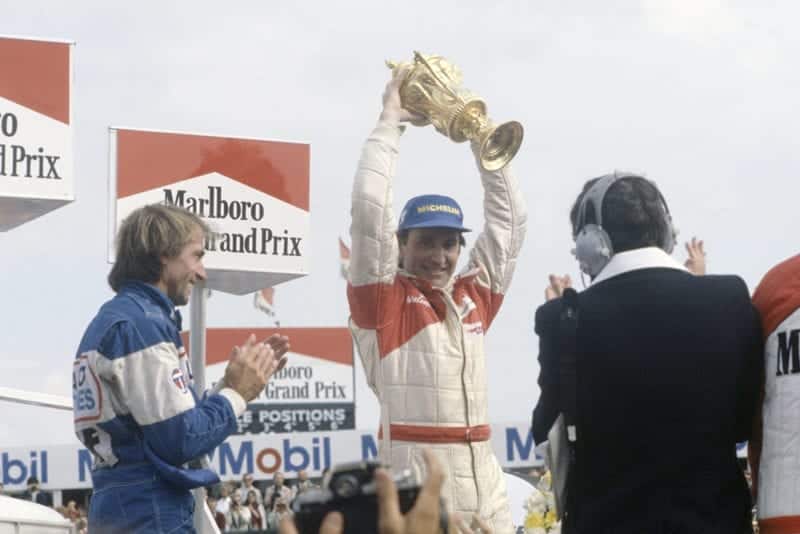 John Watson, 1st position and Jacques Laffite, 3rd position on the podium.