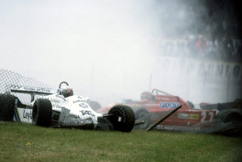 L-R: Alan Jones (Williams FW07C) becomes a victim of the catch fencing after getting caught up in the accident of Gilles Villeneuve, (Ferrari 126CK).